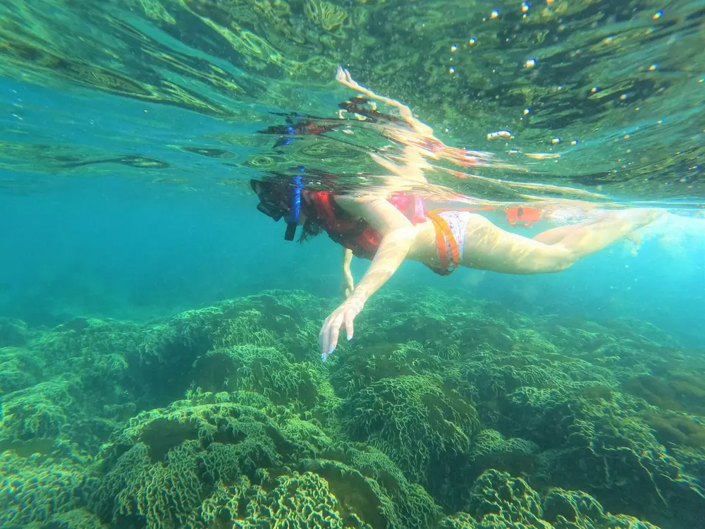 A women swim at the best snorkeling spots around Phuket