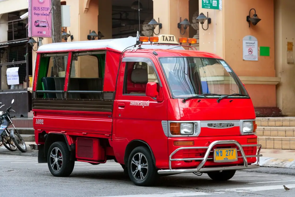 Traditional red Phuket tuk-tuk taxi on a local road
