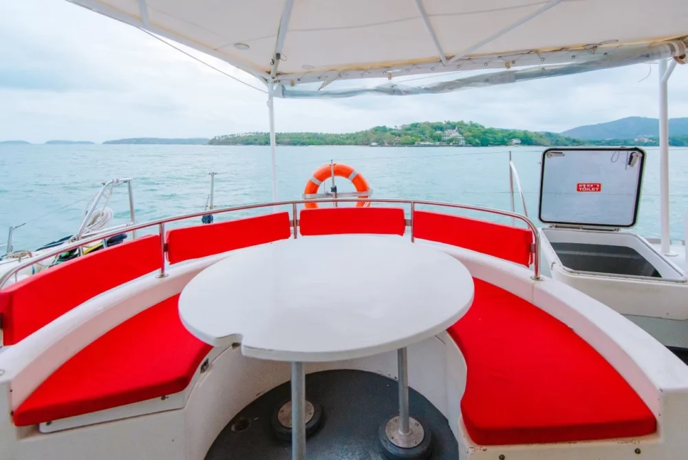 Comfortable red seating area inside Smile Rainbow Catamaran