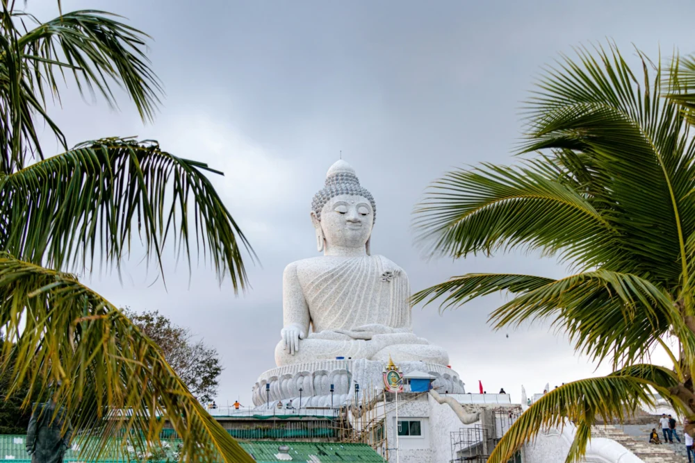 Big Buddha Phuket visible between coconut trees on Nakkerd Hill