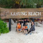 Tour guide taking a family photo at Kahung Beach on Coral Island Phuket