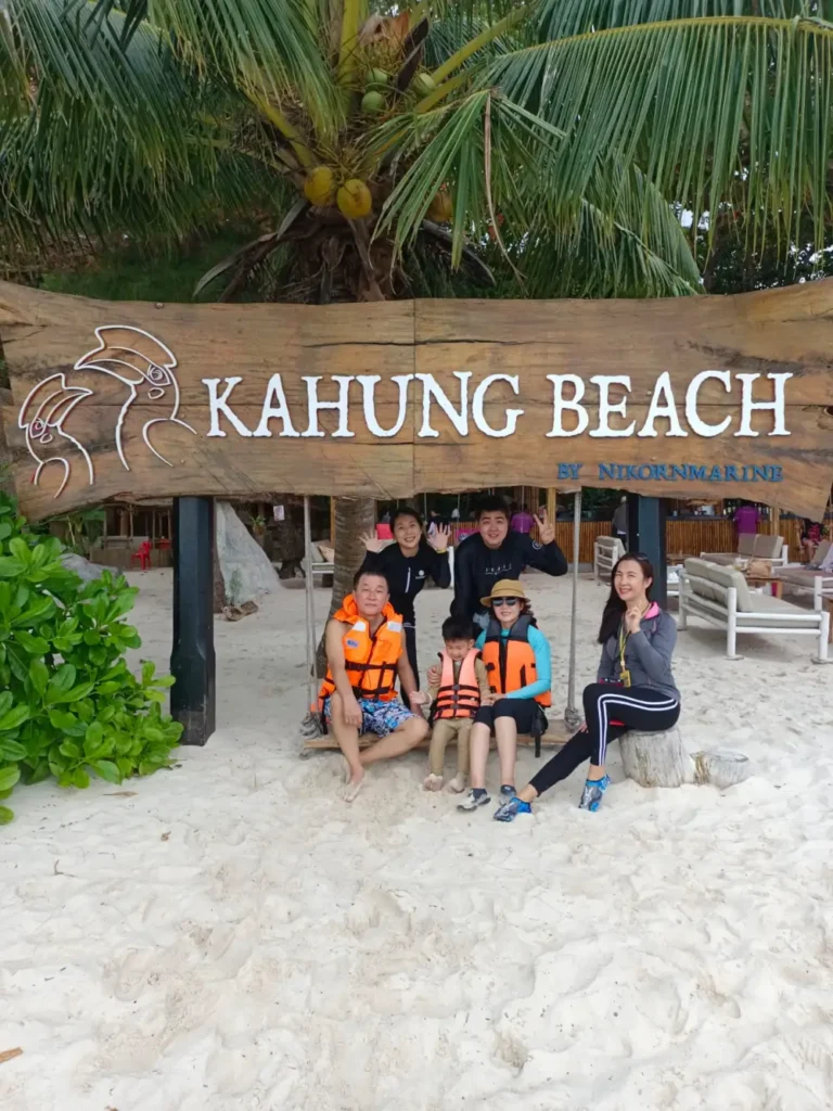 Tour guide taking a family photo at Kahung Beach on Coral Island Phuket