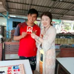 A Phuket tour guide receiving a handmade souvenir from a traveler at Racha Island
