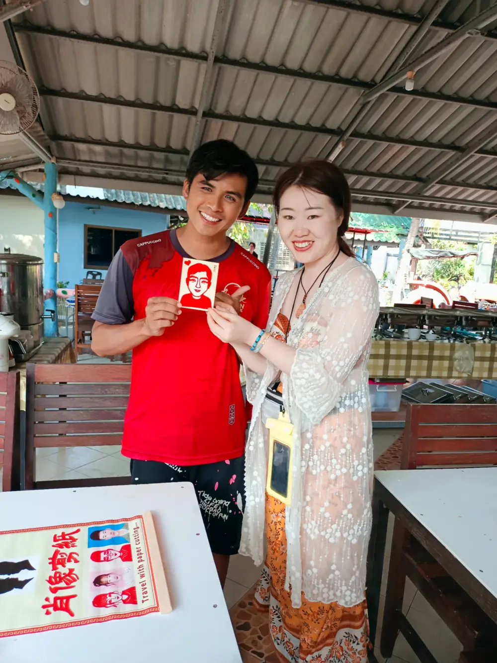 A Phuket tour guide receiving a handmade souvenir from a traveler at Racha Island