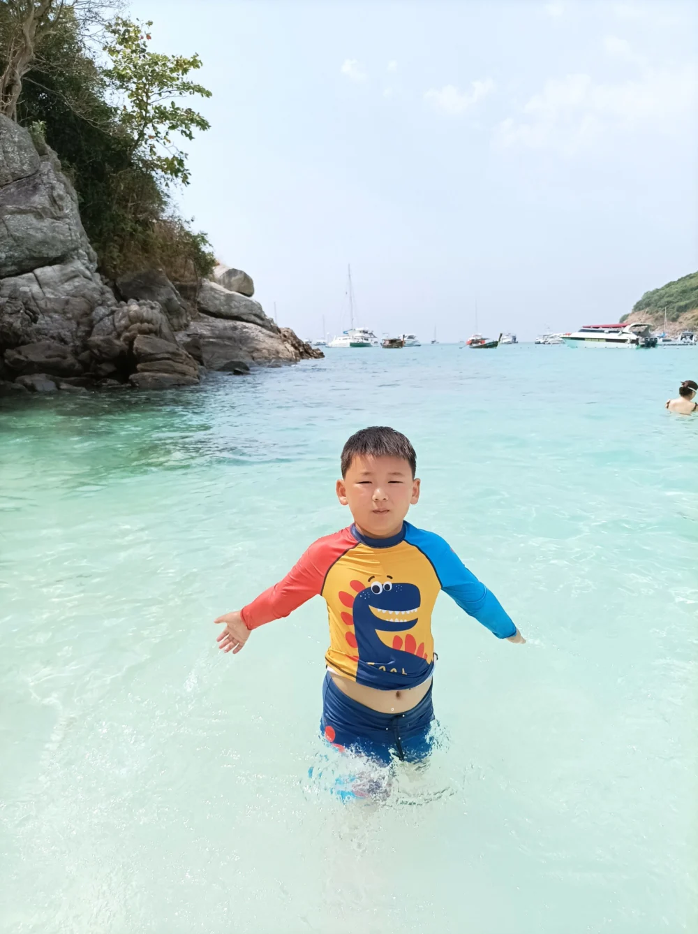 Child standing in shallow water at Patok Bay on Racha Island Phuket