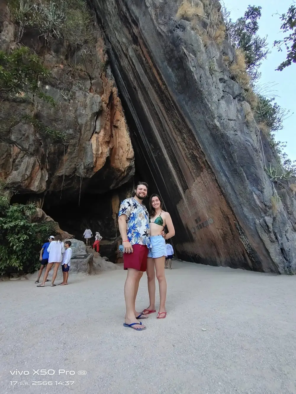 游客站在 Khao Phing Kan 石灰岩山壁前拍照