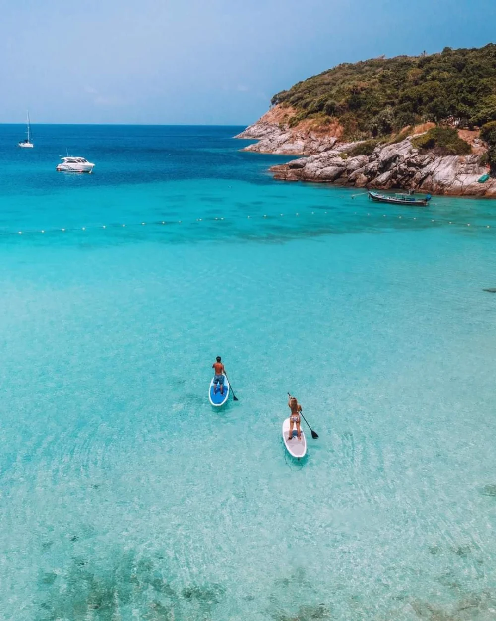 Aerial view of Patok Beach at Racha Island with two people on a paddle board