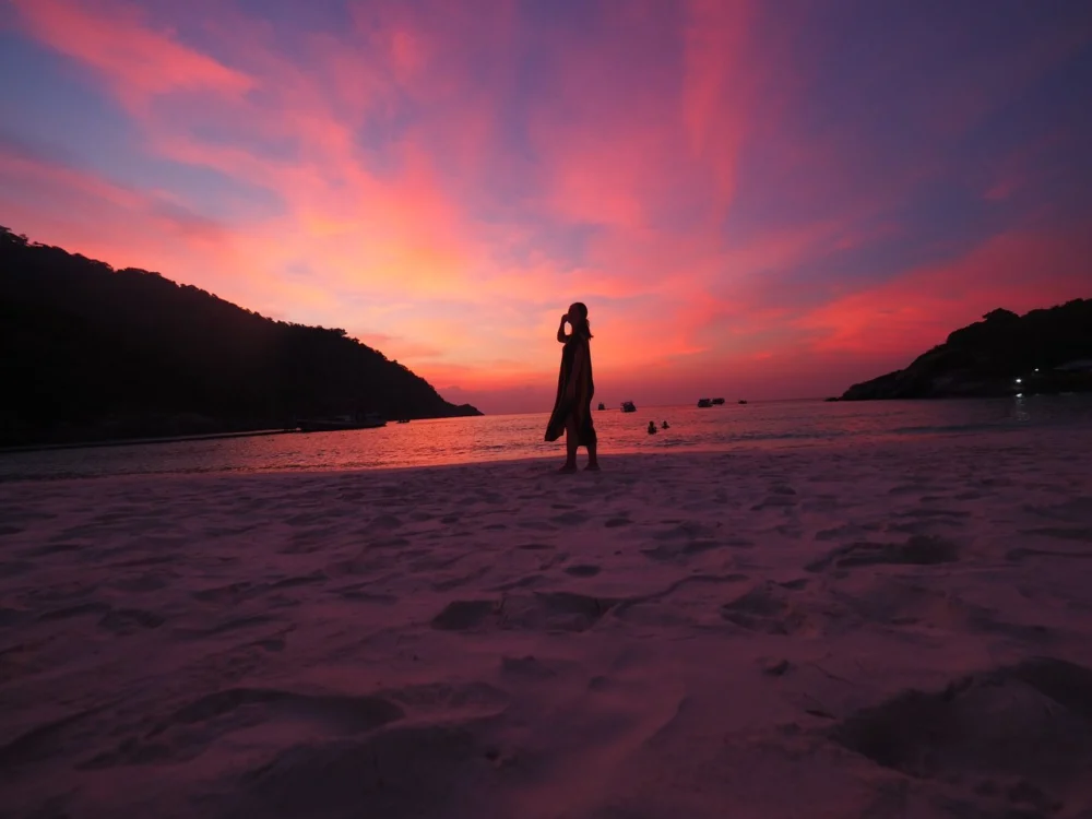 Silhouette of a woman watching the sunset from Patok Beach on Racha Island