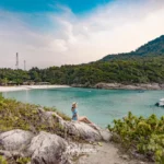 A woman sitting at the Racha Island viewpoint above Patok Beach
