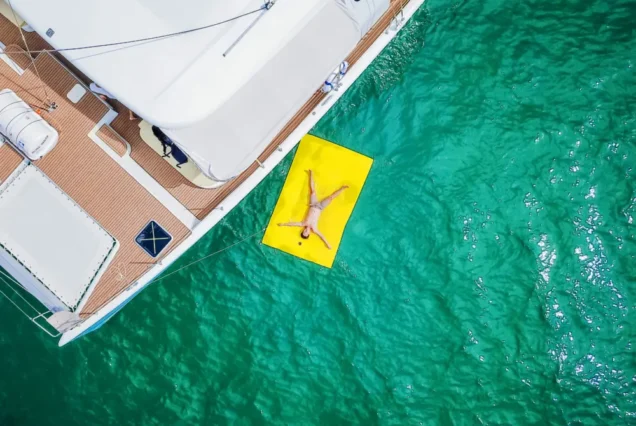 Silver Catamaran water play area with guest relaxing on the sea platform