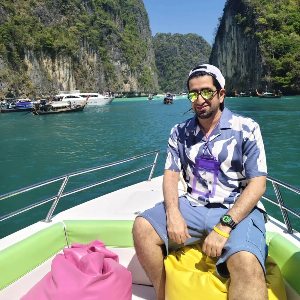 A man sitting quietly on the bow of a speedboat in Pileh Lagoon