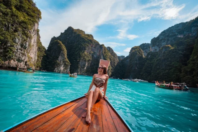 Traveller posing on a traditional Thai long-tail boat