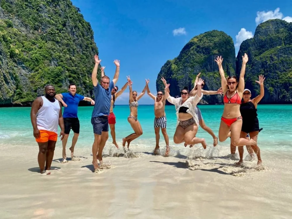 Travellers celebrating together on Maya Bay beach