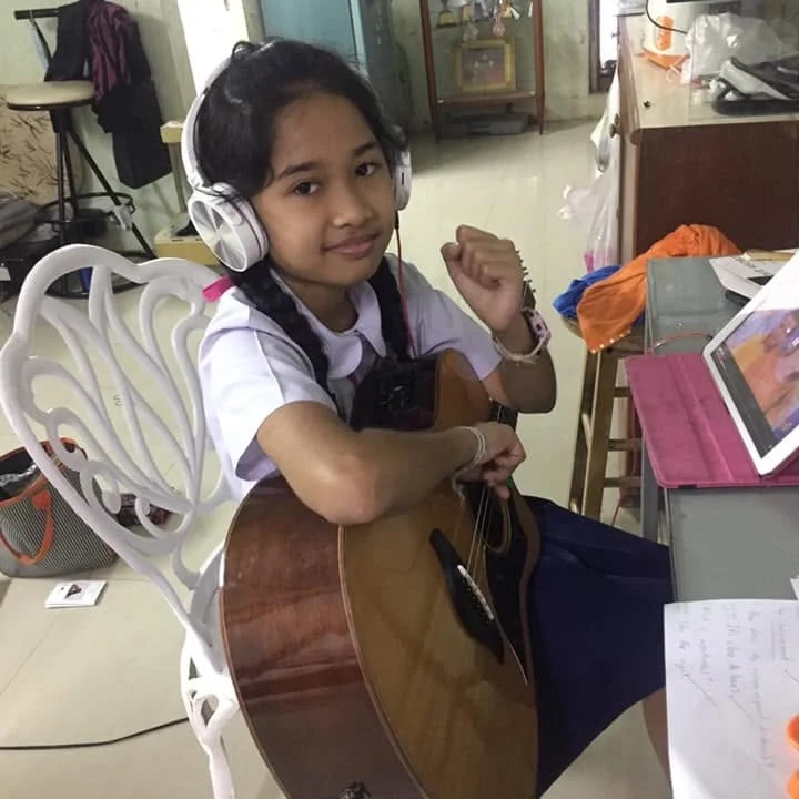 Childhood photo of Nene Royal holding a guitar