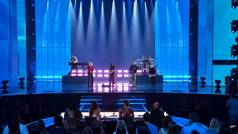 Nene Royal and Linkin Park performing on the AGT stage, seen from behind the judges