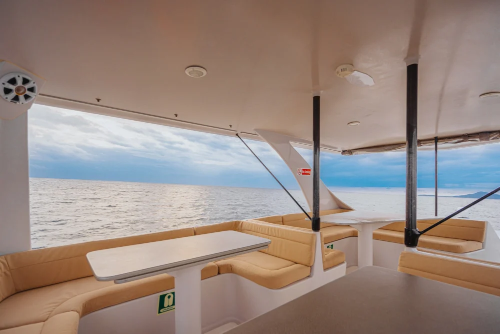 L-shaped sofas and tables inside the VIBES yacht lounge