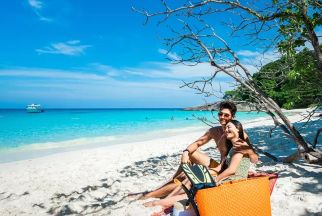 Couple on a Similan beach with snorkeling and beach equipment