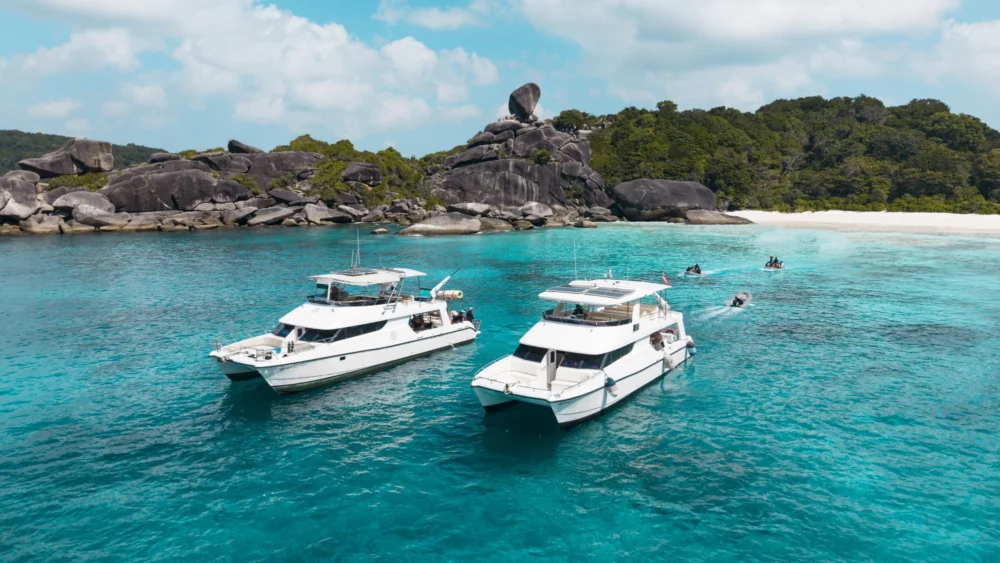 Two Flash No.7 catamaran yachts beside the island shore