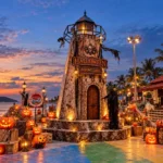 AI-generated illustration of a Halloween lighthouse and glowing pumpkins beside Patong Beach