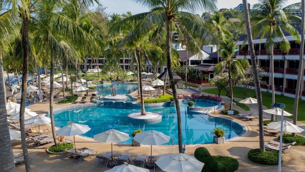 Palm trees, loungers and a swimming pool at Katathani Phuket Beach Resort
