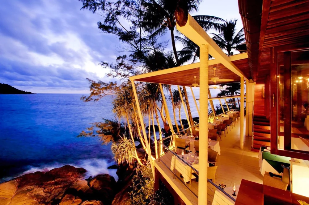 Sea-view dining terrace at Mom Tri's Kitchen in the evening