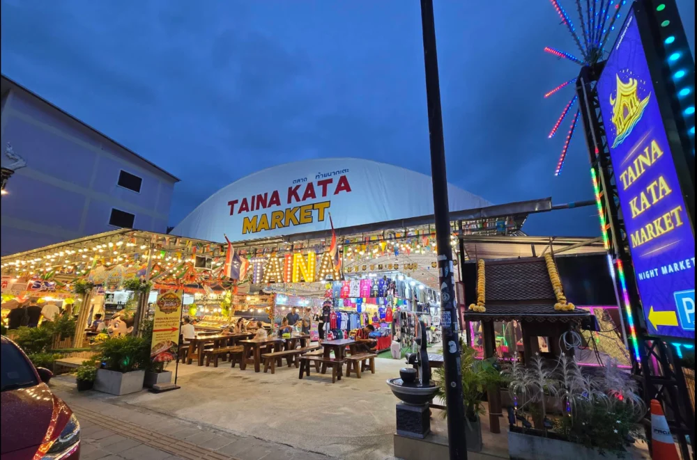 Illuminated Taina Kata Market entrance and food stalls in the evening