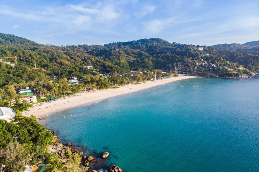 Aerial view of the curved sandy beach and wooded hills at Kata Noi