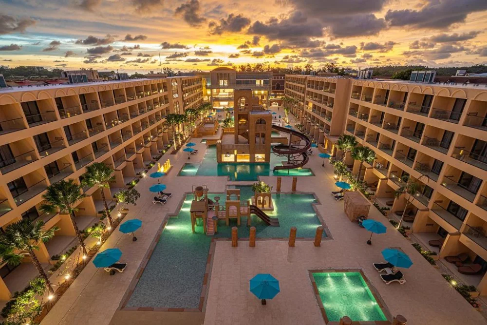 Pamookkoo Resort pools and central waterslide tower at dusk