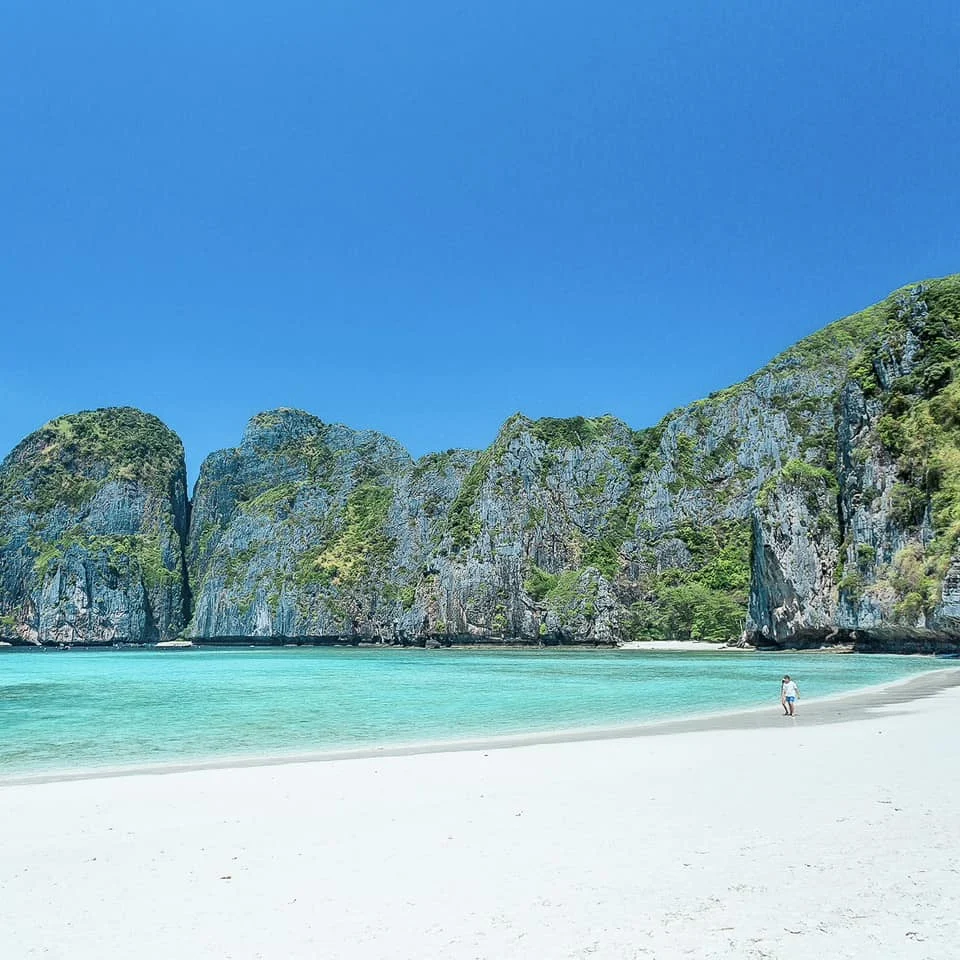White sand and turquoise water framed by limestone cliffs at Maya Bay in the Phi Phi Islands