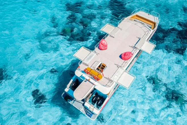 Aerial view of the Rainbow catamaran over clear Similan water