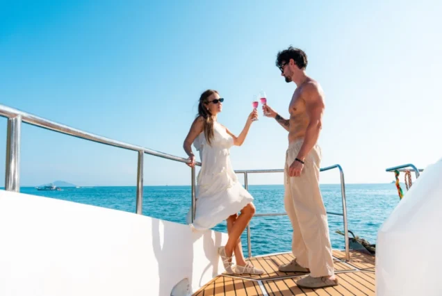 Guests posing at the Taurus bow against a blue sea backdrop